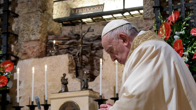 The Pope prays at the tomb of St Francis in Assisi. Picture: AFP