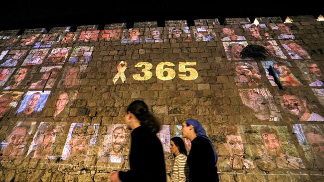 A yellow ribbon along with the number 365, signifying the number of days since the October 7, 2023 attacks carried out by Palestinian militants from the Gaza Strip, is projected along with pictures of the victims of the attacks along the old city walls of Jerusalem. Picture: Ahmad Gharabli/AFP