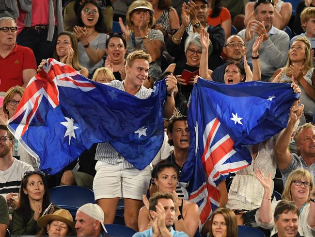 Fans holding an Australian flag are seen during the match between Alex de Minaur of Australia and Rafael Nadal of Spain on day five of the Australian Open tennis tournament in Melbourne, Friday, January 18, 2019. (AAP Image/Lukas Coch) NO ARCHIVING, EDITORIAL USE ONLY