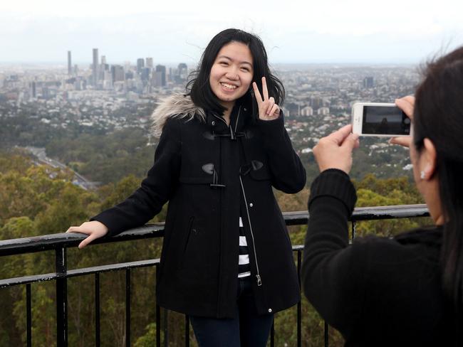 The Queensland government is trying to attract more tourists to Queensland. Tam Yee Tung and Tam Sun Wan photograph themselves on top of Mount Cootha.