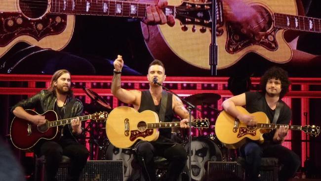 Robbie Williams with Tim Metcalfe and Flynn Francis on stage in Melbourne last year.