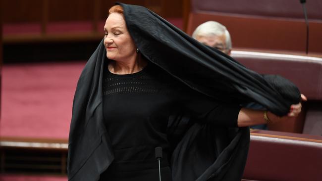 One Nation Senator Pauline Hanson takes off the burqa during Question Time at Parliament House. Picture: AAP