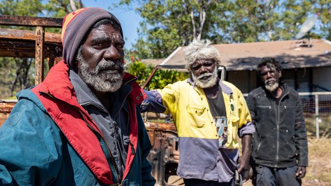 Brothers Patrick, left, Cassima and Gregory Narndu with Patrick’s burnt-out truck outside his ransacked house in Wadeye. Picture: Amos Aikman