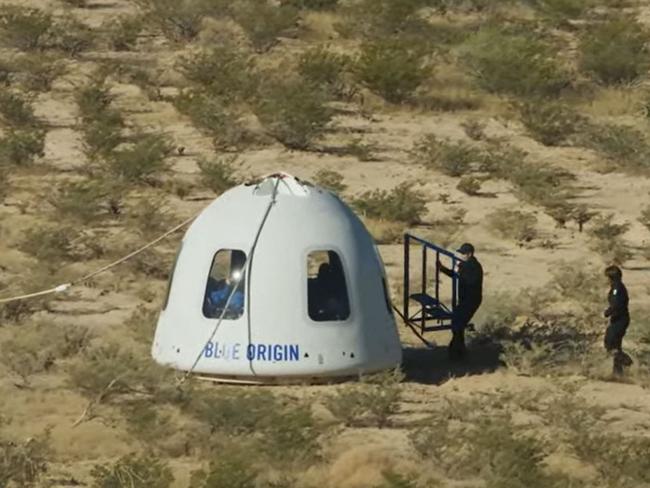 In this still image taken from a Blue Origin video, recovery crews reach the New Shepard NS-18 mission capsule after landing. Picture: AFP