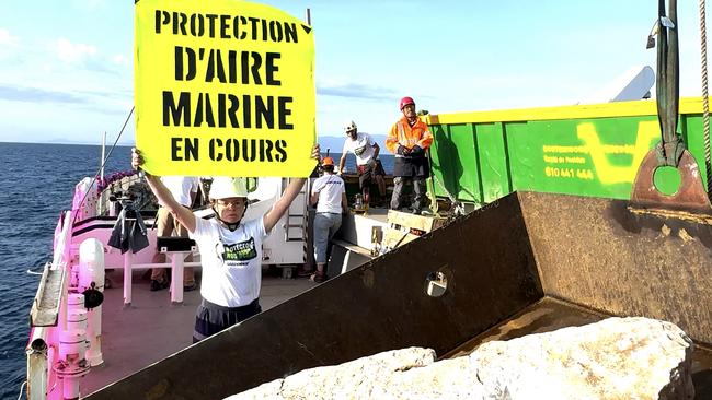 An activist on board Greenpeace's Arctic Sunrise ship as it transports limestone rocks in a marine park off the coast of southern France to prevent trawling. Picture: AFP