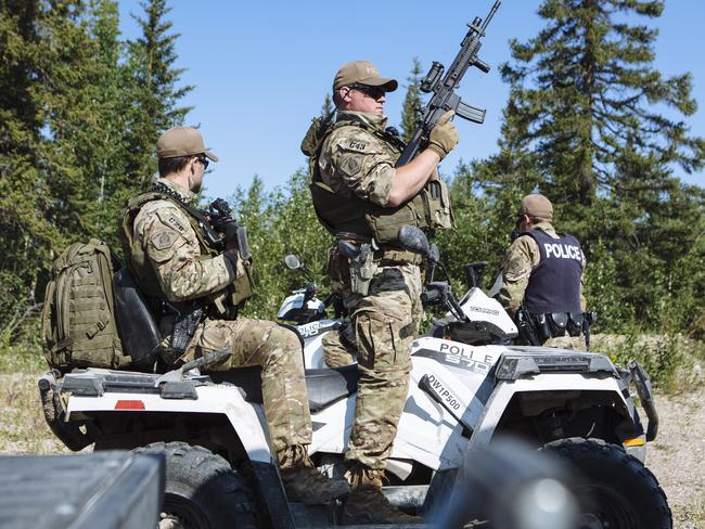 Members of the Royal Canadian Mounted Police Emergency Response Team prepare to search an area near where the burned out Toyota Rav 4 was found burnt out. Picture: Angus Mordant for News Corp Australia