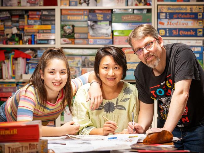 Mensa member Joerg Henrichs, right, does puzzles with his wife Yoko and daughter Lia, who is also a member of Mensa. Picture: Mark Stewart