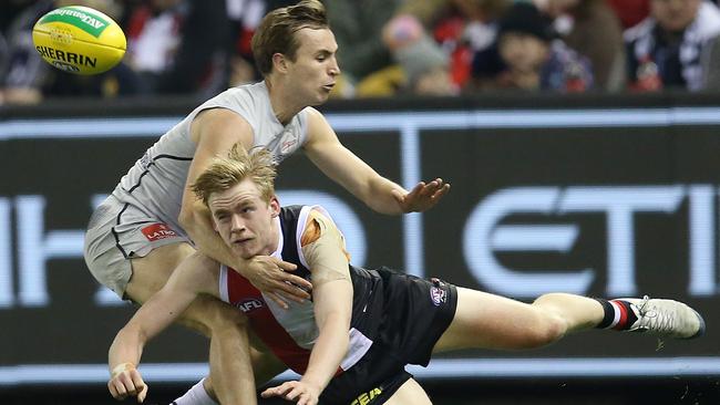 St Kilda’s Ed Phillips clears by hand under pressure from Carlton’s Lochie O’Brien. Picture: Michael Klein