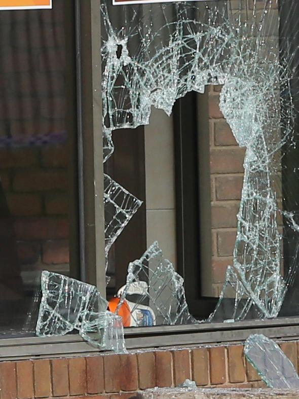 Barwon Health Foundation collection tin by the broken window. Fish and Chips and Pizza site in Corio where a man was critically injured. Picture: Alan Barber