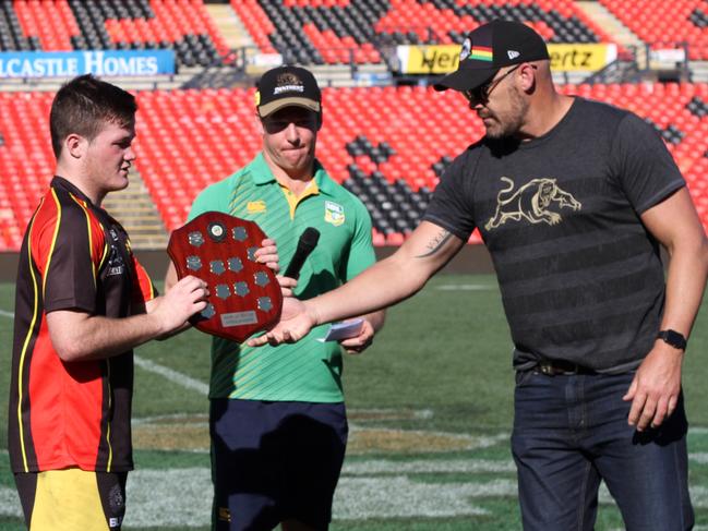 Mark Geyer and Ben James present the trophy to Loyola Senior High team captain Ayden Carling and vice captain Clinton Aiono.