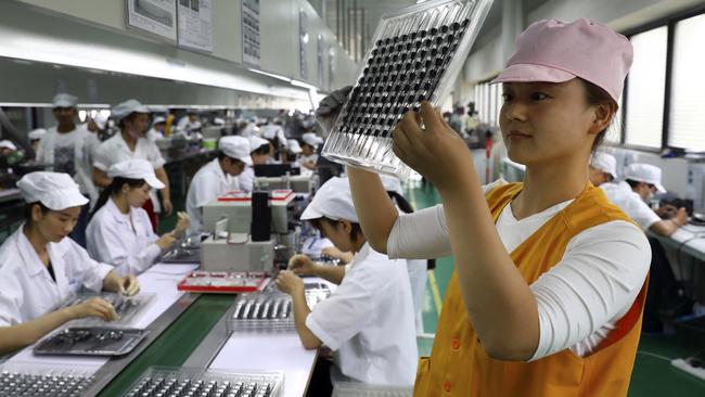 A worker inspects the micro-motors for handsets at a factory in Huaibei in central China’s Anhui province. Picture: AP.