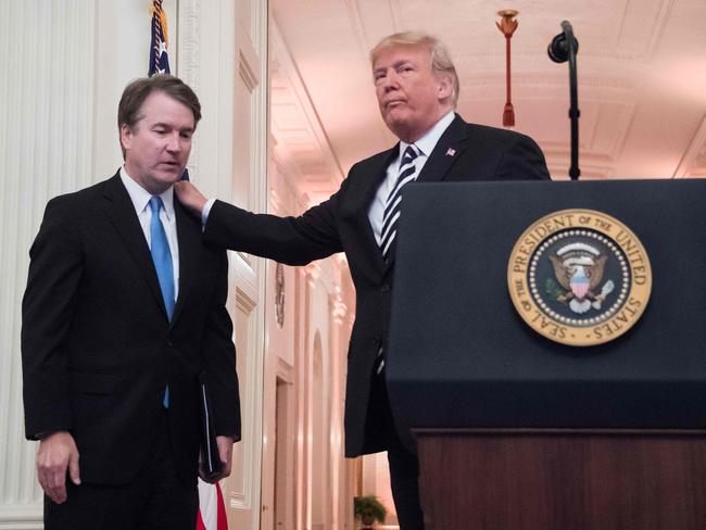 Donald Trump pats Associate Justice of the US Supreme Court Brett Kavanaugh on the back during a ceremonial swear-in at the White House in Washington, DC. Picture: AFP