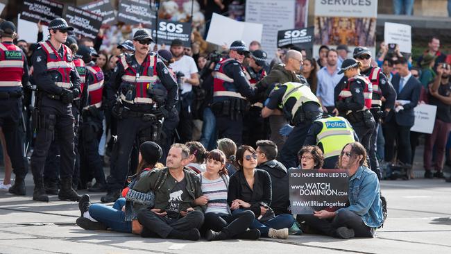 Police move in on animal rights protesters who had blocked the intersections of Flinders and Swanston Street, in Melbourne, Monday, April 8, 2019. Animal rights protesters are slowly being arrested and dragged into police vans after blocking a major Melbourne CBD intersection. (AAP Image/Ellen Smith) NO ARCHIVING