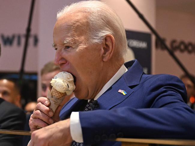 TOPSHOT - US President Joe Biden (R), flanked by host Seth Meyers (L), eats an ice cream cone at Van Leeuwen Ice Cream after taping an episode of "Late Night with Seth Meyers" in New York City on February 26, 2024. (Photo by Jim WATSON / AFP)