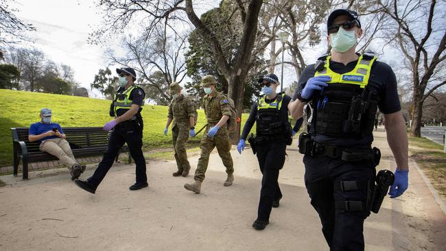 Police officers and army personnel patrol the Tan on Sunday. Picture: NCA NewsWire/David Geraghty