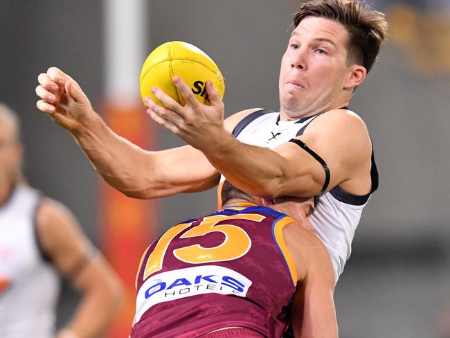 Toby Greene gets a handball away despite Dayne Zorko’s tackle.