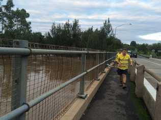 Gympie council workers clearing debri from Kidd Bridge early this morning . Picture: Frances Klein