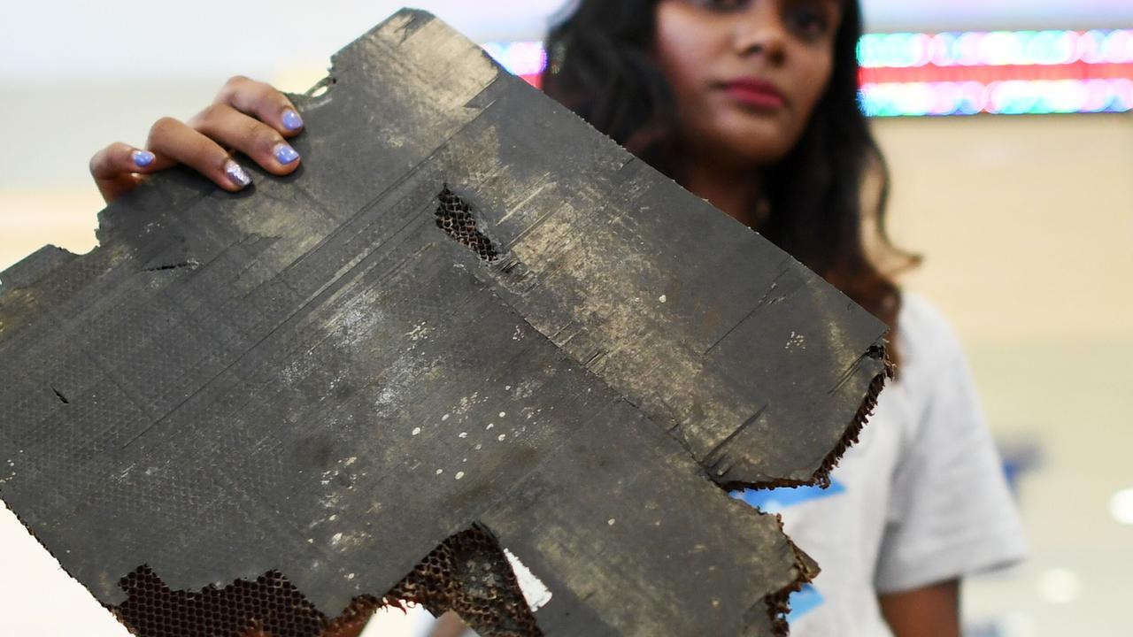 Grace Subathirai Nathan, daughter of Malaysian Airlines flight MH370 passenger Anne Daisy, shows a piece of debris believed to be from flight MH370. Picture: Mohd Rasfan/AFP.