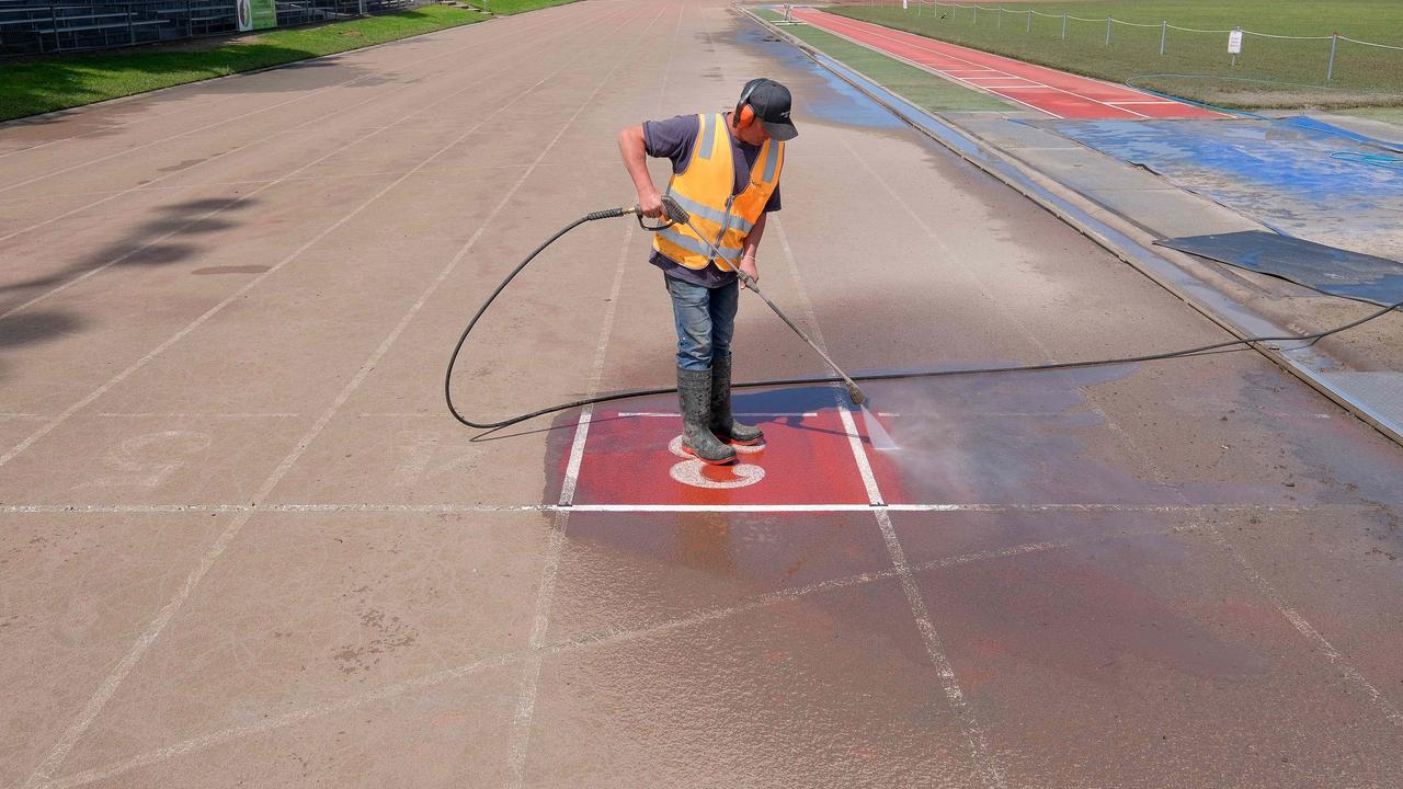 A contractor cleaning up Landy field athletics track since after the banks of the Barwon River burst. Picture: Mark Wilson