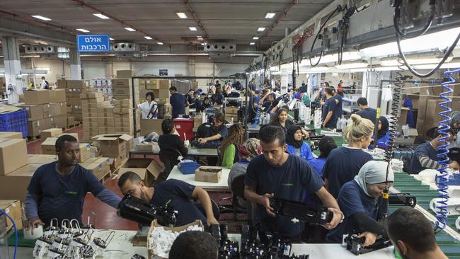 Employees work at the new SodaStream factory built deep in Israel's Negev Desert next to the city of Rahat, Israel, that will replace the West Bank facility when it shuts down in two weeks time.