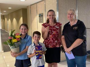 Detectorist Kazz Preston with one happy family after the uncovered a missing wedding ring on Burleigh beach.