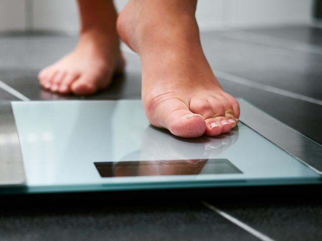 Female bare feet with weight scale in the bathroom, scales generic