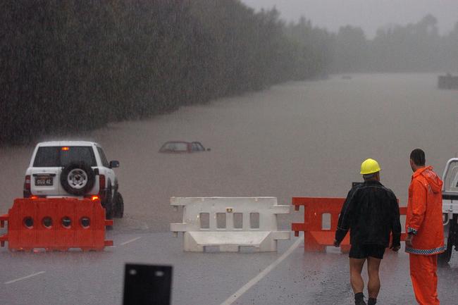 Gold Coast, June 30, 2005. A submerged vehicle at a flooded road at Robina on Queensland’s Gold Coast today. Widespread flooding has hit the popular tourist area, known for its sunshine and sandy beaches, with reports of rainfall reaching 80mm per hour in some regions. (AAP Image/Tony Phillips)