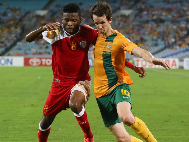 Robbie Kruse comes to grips with the Oman defence during a World Cup qualifier.