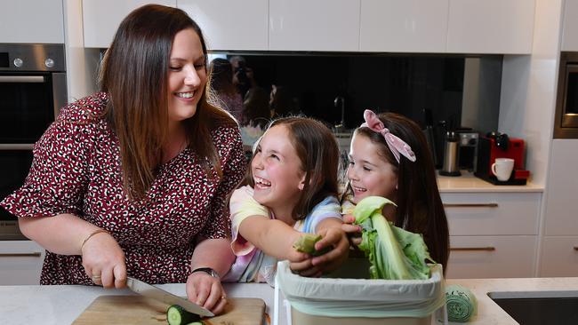 Alicia Sandercock with her daughters Summer, 6 and Ruby, 8, use the Kitchen Caddy to dispose of their kitchen green waste at their Warradale home. Picture: Mark Brake