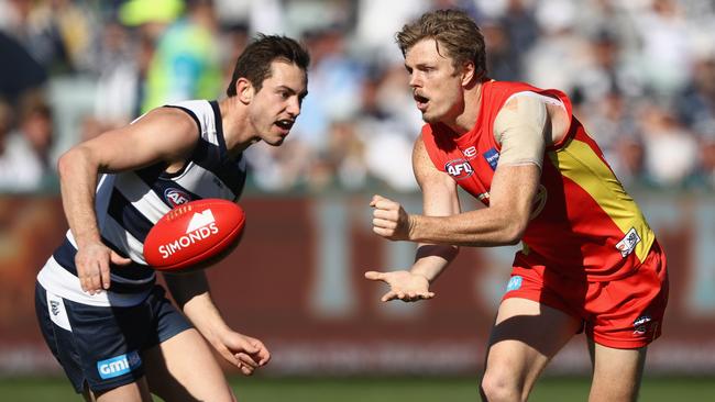 Nick Holman handballs under pressure from Daniel Menzel.