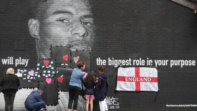 Local residents put messages of support on plastic covering graffiti on the vandalised mural of England player Marcus Rashford in Manchester. Picture: Getty Images