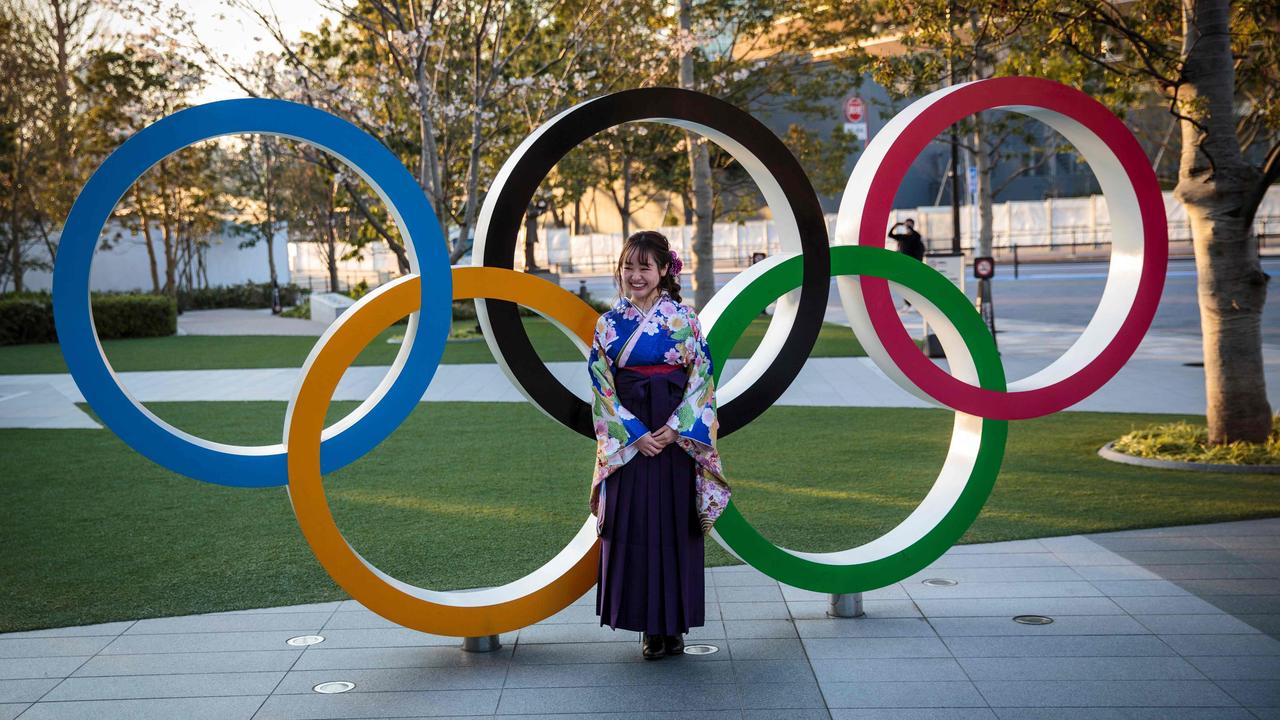 A Japanese woman wears a traditional kimono as she poses next to the Olympic rings in front of the Japan National Stadium, the main venue for the Tokyo Olympic Games. Picture: AFP