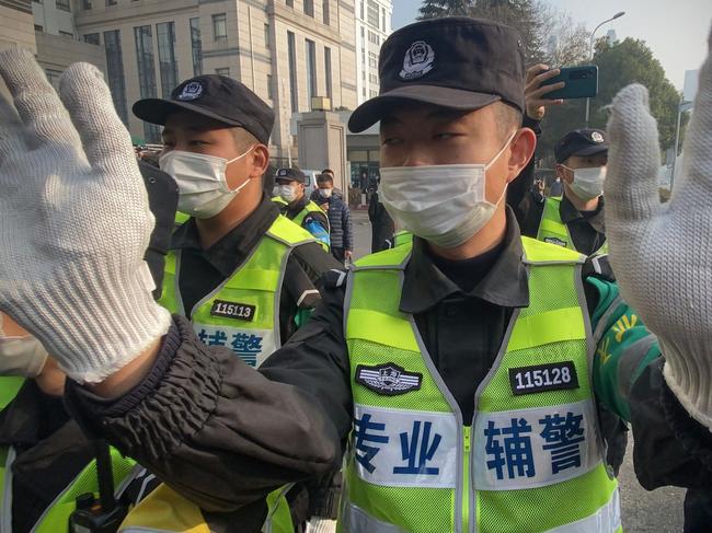 Police attempt to stop journalists from recording footage outside the Shanghai Pudong New District People's Court, where Chinese citizen journalist Zhang Zhan - who reported on Wuhan's Covid-19 outbreak and placed under detention since May - is set for trial in Shanghai on December 28, 2020. (Photo by Leo RAMIREZ / AFP)