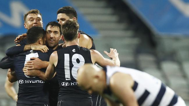 Carlton players celebrate their upset victory over flag contender Geelong.