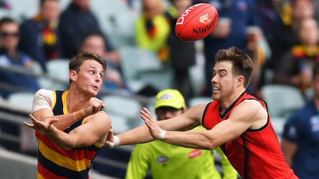 Adelaide’s Matt Crouch handballs over Zach Merrett at Adelaide Oval Picture: Getty Images