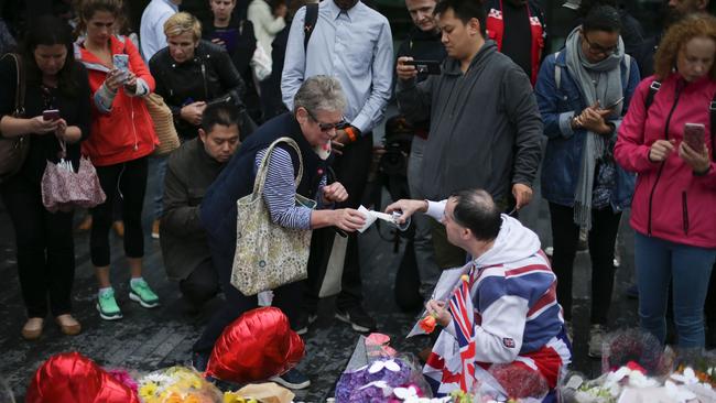 People leave tributes at a pile of flowers outside City Hall in London. Picture: AFP