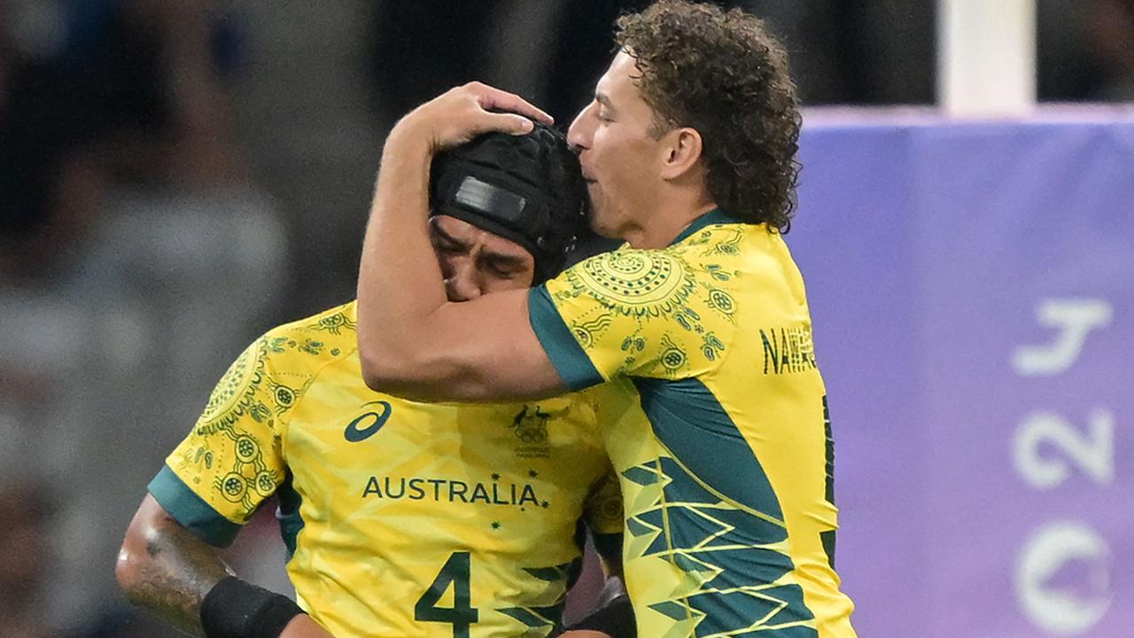 Australia players celebrate winning the men's quarterfinal rugby sevens match between Australia and USA during the Paris 2024 Olympic Games at the Stade de France in Saint-Denis on July 25, 2024. (Photo by CARL DE SOUZA / AFP)