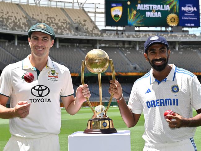 Australiaâs captain Pat Cummins (L) and Indiaâs captain Jasprit Bumrah pose with the trophy at Optus Stadium in Perth on November 21, 2024, ahead of the first cricket Test between Australia and India. (Photo by SAEED KHAN / AFP) / -- IMAGE RESTRICTED TO EDITORIAL USE - STRICTLY NO COMMERCIAL USE --