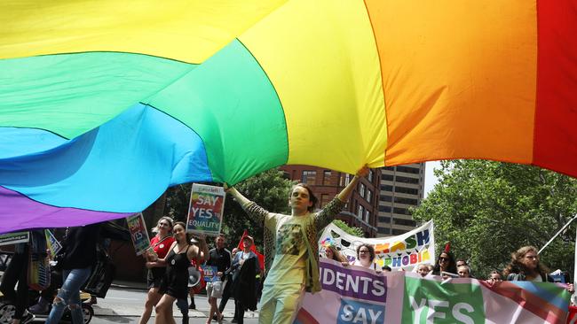 A man holds a rainbow flag during a march in support of marriage equality