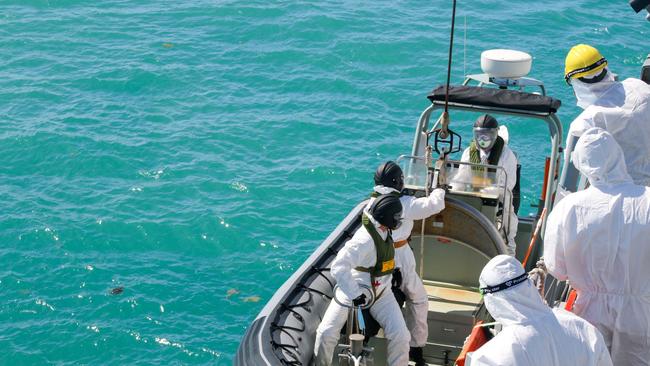 Royal Australian Navy sailors from HMAS Brisbane prepare to board a Rigid-Hulled Inflatable Boat to conduct search and rescue operations in the vicinity of Lindeman Island.