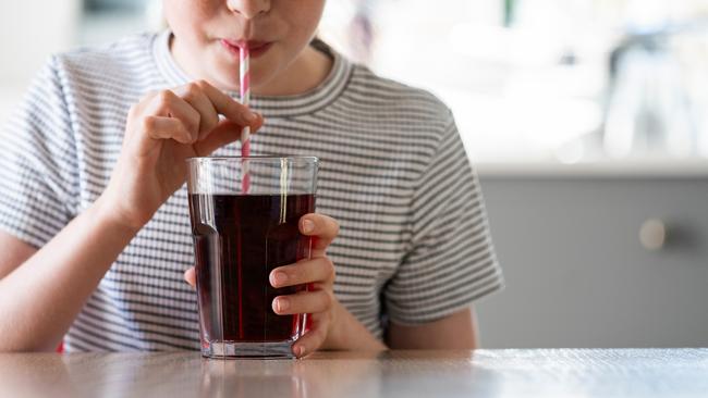 IStock generic of kids drinking -  Close Up Of Girl Drinking Sugary Fizzy Soda From Glass With Straw