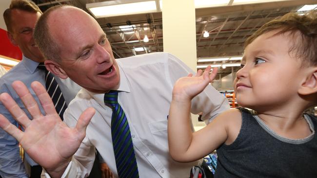 Qld Premier Campbell Newman talks to young Ethan Mayne in a shopping trolley as he greets shoppers flanked by transport minister Scott Emerson in a giant Costco store as he continues to campaign in the Queensland state election , in the state electorate of Murrumba at North Lakes , Brisbane .