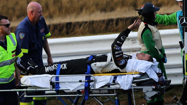 Will Davison gives spectators a wave while being loaded into an ambulance at Symmons Plains after the massive 2017 pile-up. Picture: Chris Kidd