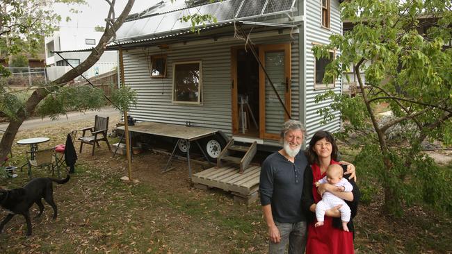 Tiny House builder Fred Schultz is building a tiny house on a trailer at his wifeÕs family home in Templestowe. Manningham Building Council says it's illegal. He says it's not in their jurisdiction and under VicRoads, as it has no foundation and is on wheels. Fred Schultz with wife Shannon and daughter Olinda. Picture: Stuart Milligan