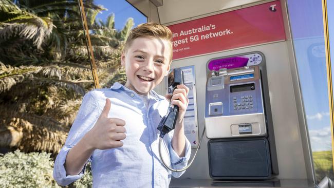 Ethan Carey, 11, at a public phone in St Kilda, Melbourne. Public payphones will be free to use from today, in a move expected to cost Telstra millions of dollars. Picture: Wayne Taylor