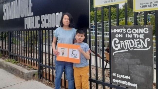 Daisy Ng stands outside Stanmore Public School with her son Andrew, who was expelled for 'problem behaviours'. Picture: Supplied