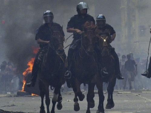 FILE - In this Dec. 20, 2001 file photo, mounted police charge anti-government demonstrators in Buenos Aires, Argentina, after the South American nation had just defaulted on more than $100 billion in foreign debt, banks were shuttered, the economy was in ruins and streets were filled with pot-banging protesters whose chants of "throw them all out" sent five presidents packing. As Argentines closely watch the 2015 financial turmoil in Greece, recalling their worst crisis 14 years ago, the architect of the South American country’s recovery says the European nation should renegotiate its debt. (AP Photo/Walter Astrada, File)