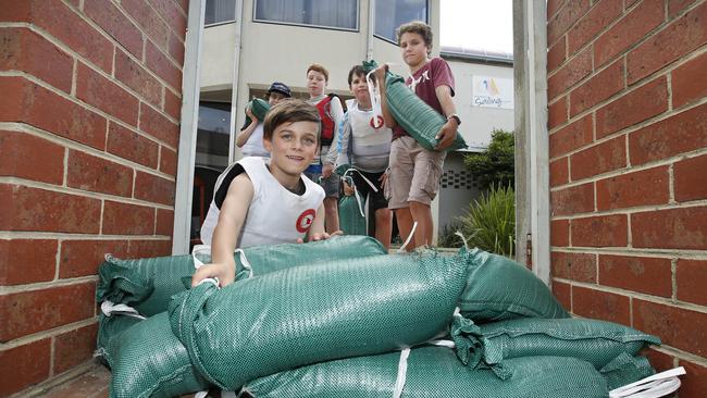 Melbourne’s Royal Brighton Yacht Club gets ready for flooding. Felix Ridley-Whittle 8, sandbags the front gate with his fellow sailors. Picture: David Caird