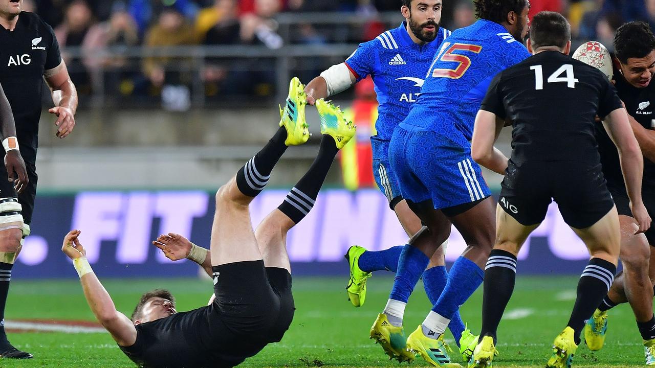 Beauden Barrett (bottom L) falls to the ground after contact in the air with France’s Benjamin Fall.