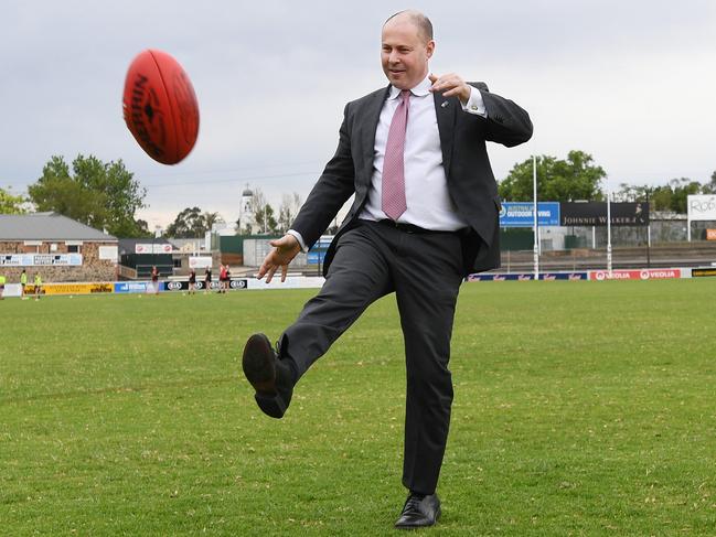 Federal Treasurer Josh Frydenberg kicks a football at Norwood Oval during a visit to Adelaide. Picture: NCA NewsWire / David Mariuz